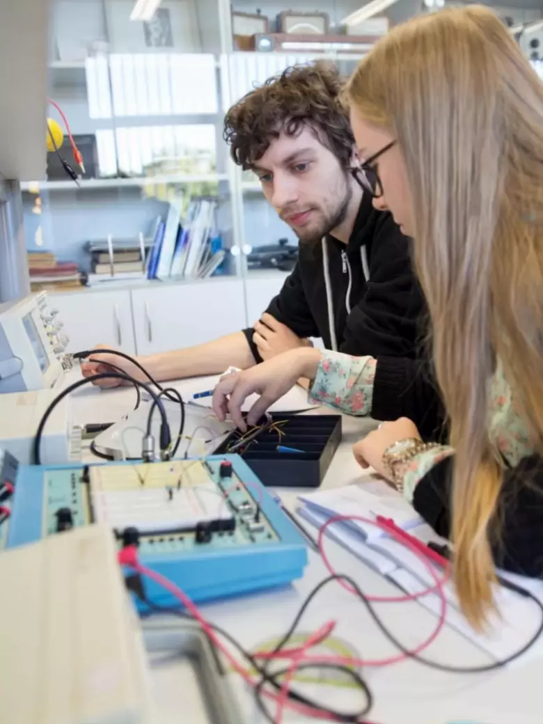 Studentai dirba su elektronikos komponentais laboratorijoje – tai praktika grįstas mokymasis, kur teorija tampa veiksmais. KTU technologijų programos leidžia eksperimentuoti su realiomis sistemomis.