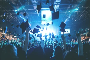 Studijos Kaune ar Vilniuje? Būsto kainų, susisiekimo ir gyvenimo kokybės palyginimas. Nuotraukoje matomi studentai po diplomų atsimėmimo, diplomų įteikimo šventės metu, švenčia mesdami kepurėles į orą.