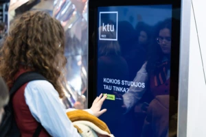 Mergina studijų mugėje žiūri į ekraną su karjeros testu ir bando nuspręsti, kaip išsirinkti studijų programą pagal savo interesus?