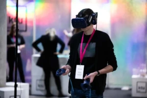 KTU geriausias universitetas Lietuvoje. Vaikinas naudojasi VR akiniais studijų mugės metu.