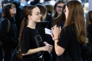 KTU išankstinis priėmimas 2026. Mergina dalyvauja studijų mugėje ir klausosi konsultacijos apie bakalauro studijas.