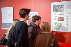 Merginos ir vaikinai prekybos centre apžiūrinėja KTU architektūros magistrų baigiamųjų darbų parodą